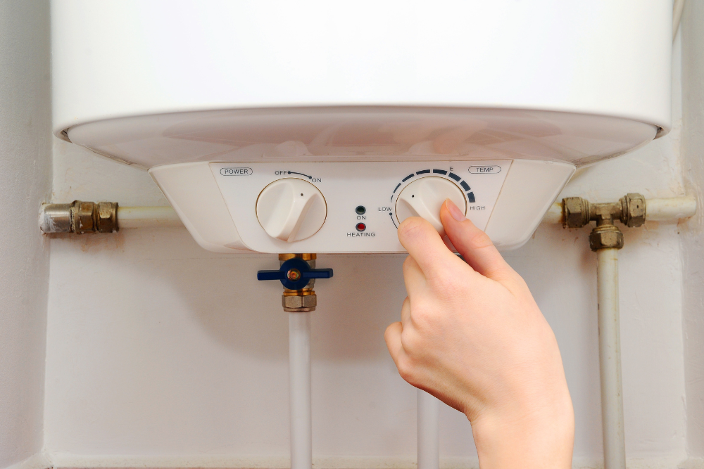 Hand turning the temperature dial on a heater to show basic operation and explain what is a water heater in a home.
